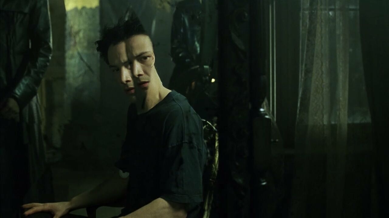 Image of Neo from the Matrix looking into a shattered mirror.